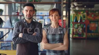 两个骄傲的小企业主站在新的宽敞咖啡馆里微笑的肖像。 成功开办企业